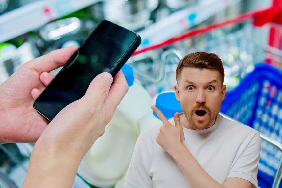 smartphone in mano supermercato uomo sorpreso